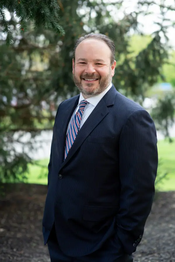 A man in a suit and tie standing outside.