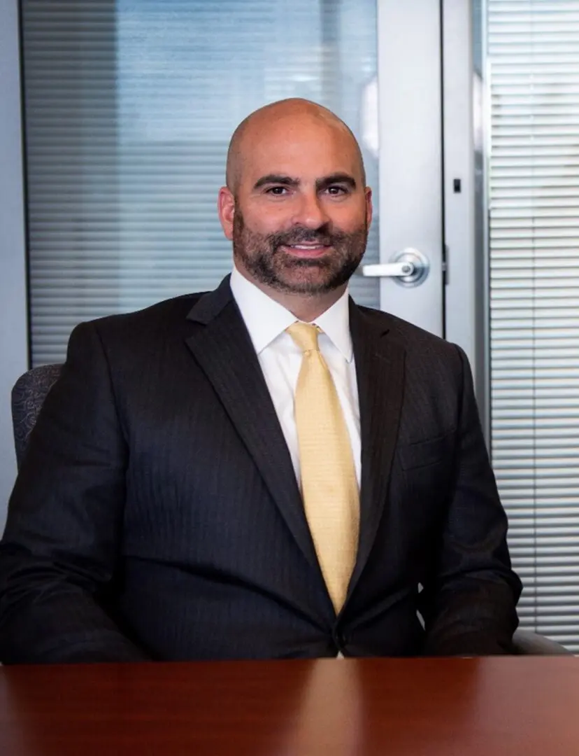 A man in suit and tie sitting at a desk.